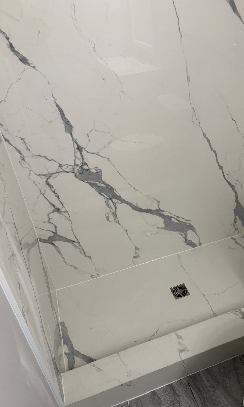 Marble-look solid surface shower walls and low-profile shower base by Brimie Contractors