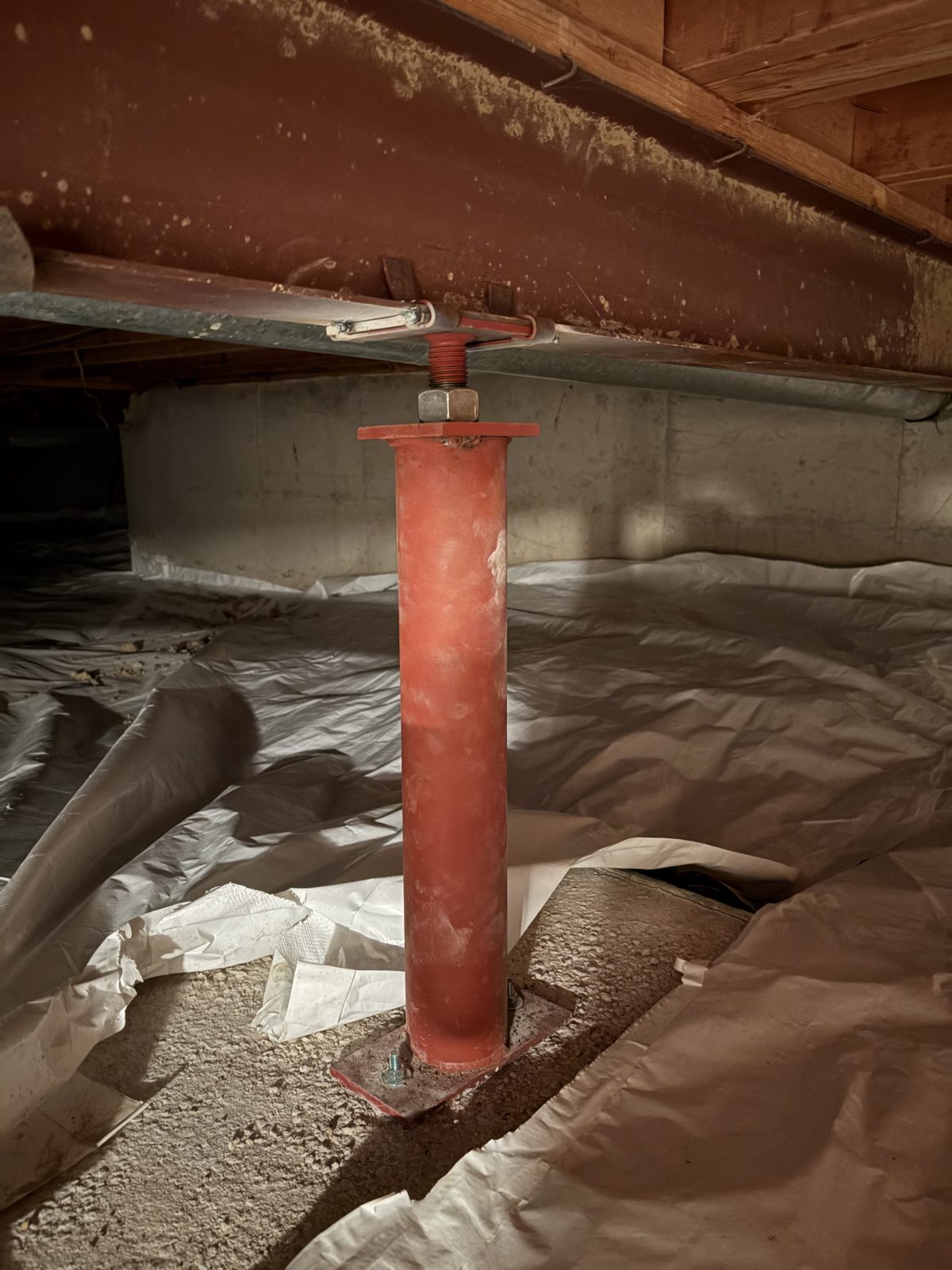 After: new red steel support post on a new footing under the main beam, Centennial