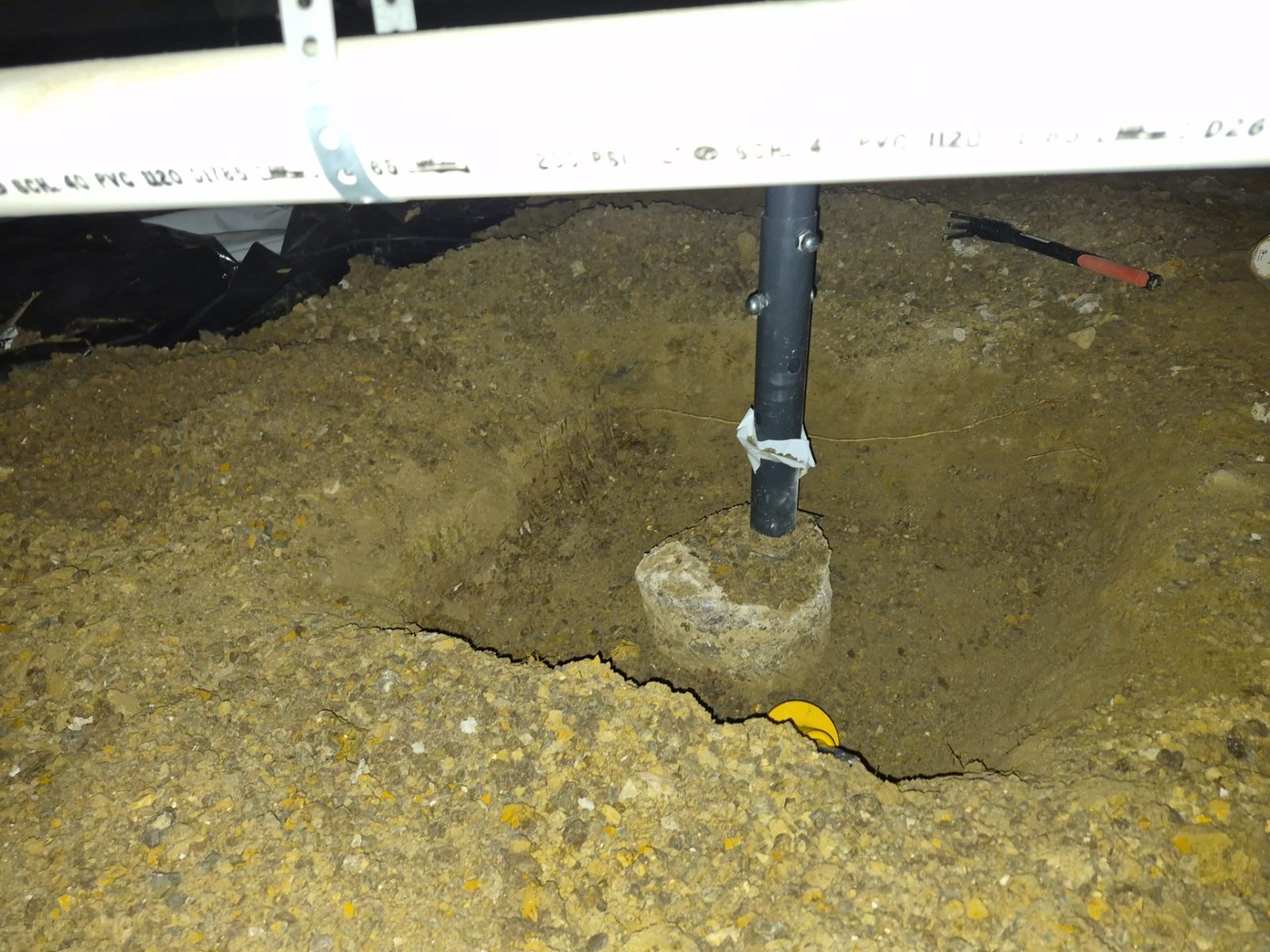 Before: gray adjustable post sitting on an old concrete pier, Centennial