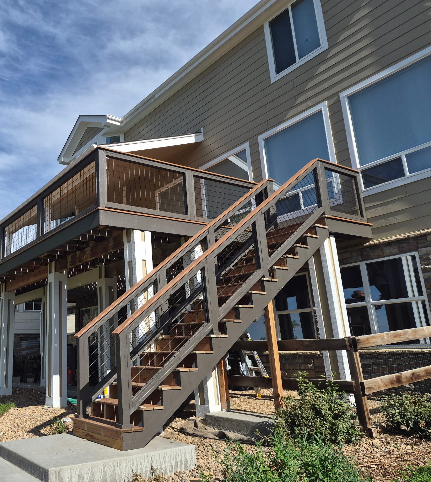 Two-story composite deck with hog-wire railing and matching stairs by Brimie Contractors