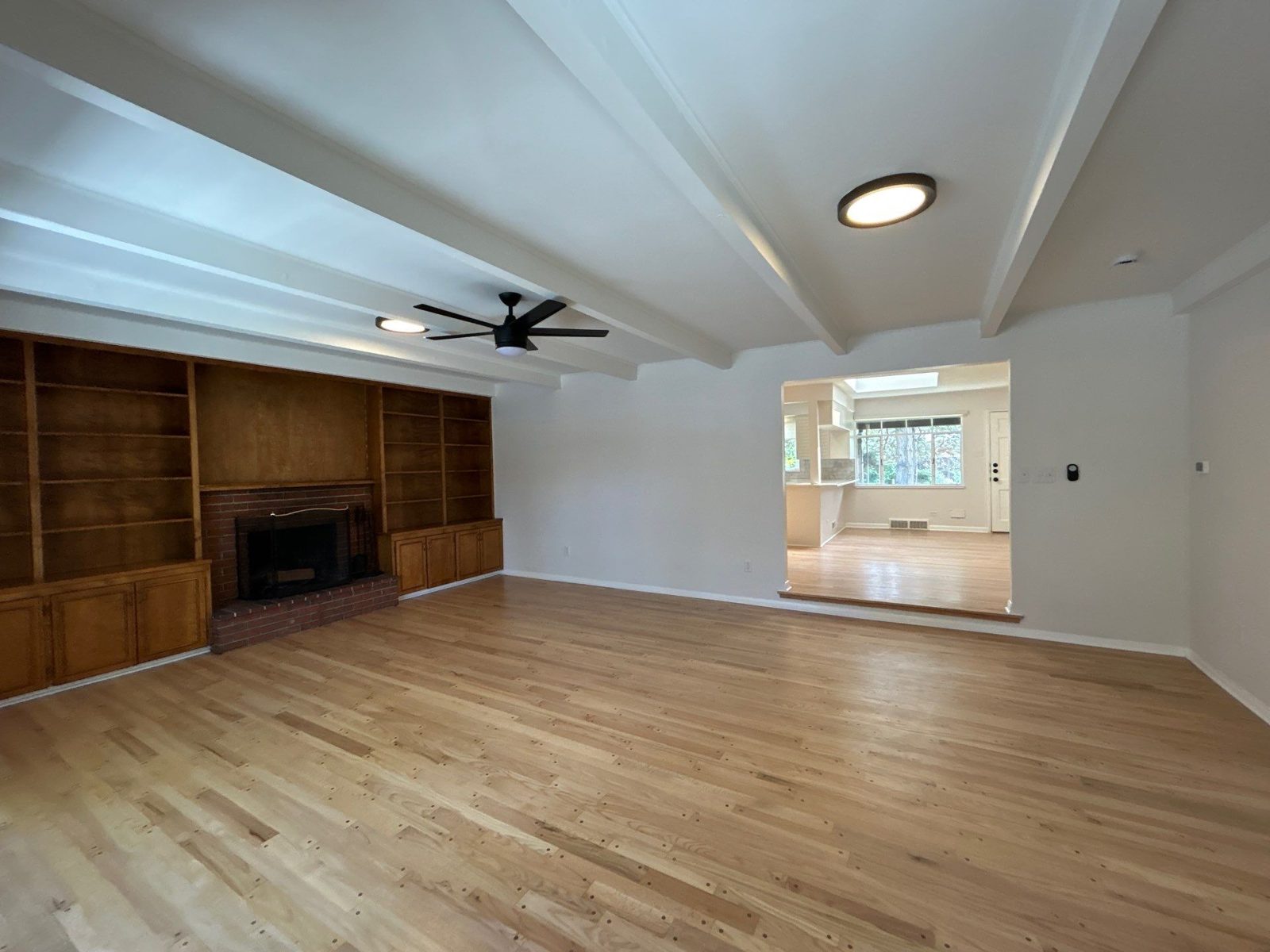 After: family room with refinished oak floors, painted beams and new ceiling fan, Denver