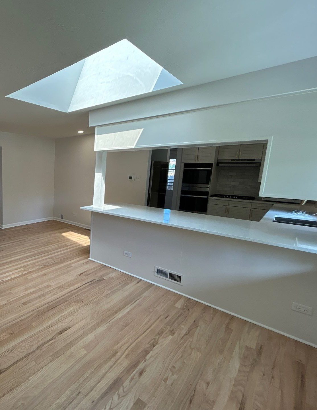 After: refinished oak floors, skylight and brass sconces in the living and dining room, Denver