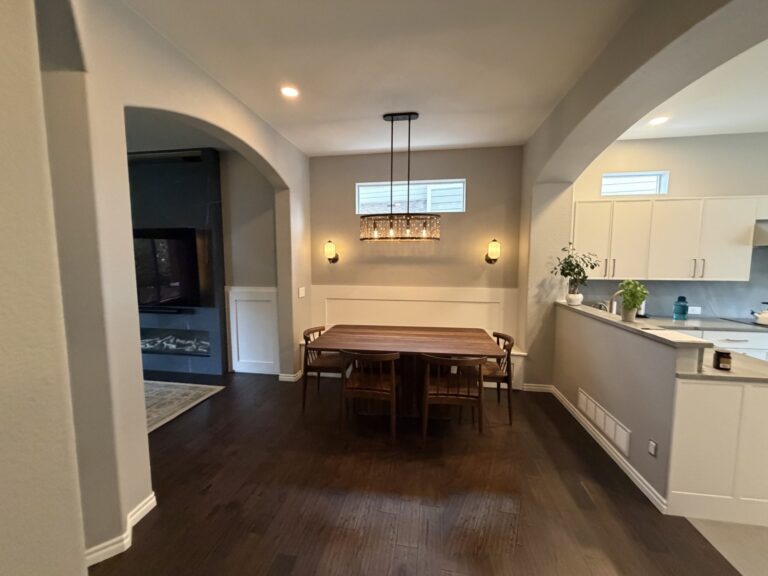 After: Highlands Ranch dining room with wainscot banquette wall, pendant light and sconces, open to the kitchen and the new fireplace wall