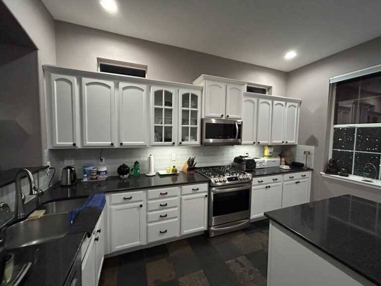 Before: Highlands Ranch kitchen with arched white cabinets, black granite counters and slate tile floor