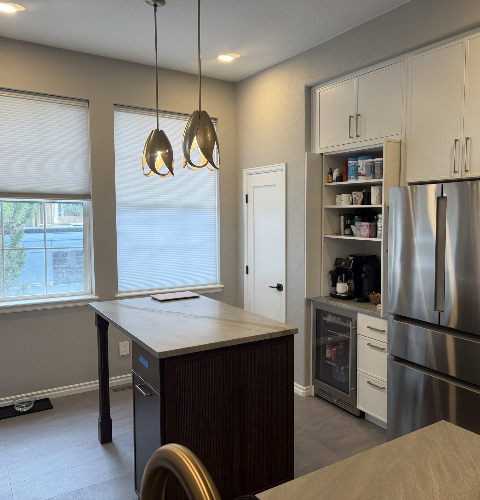 After: dark-stained island with leathered quartz top, built-in coffee bar, wine fridge and stainless fridge, Highlands Ranch kitchen