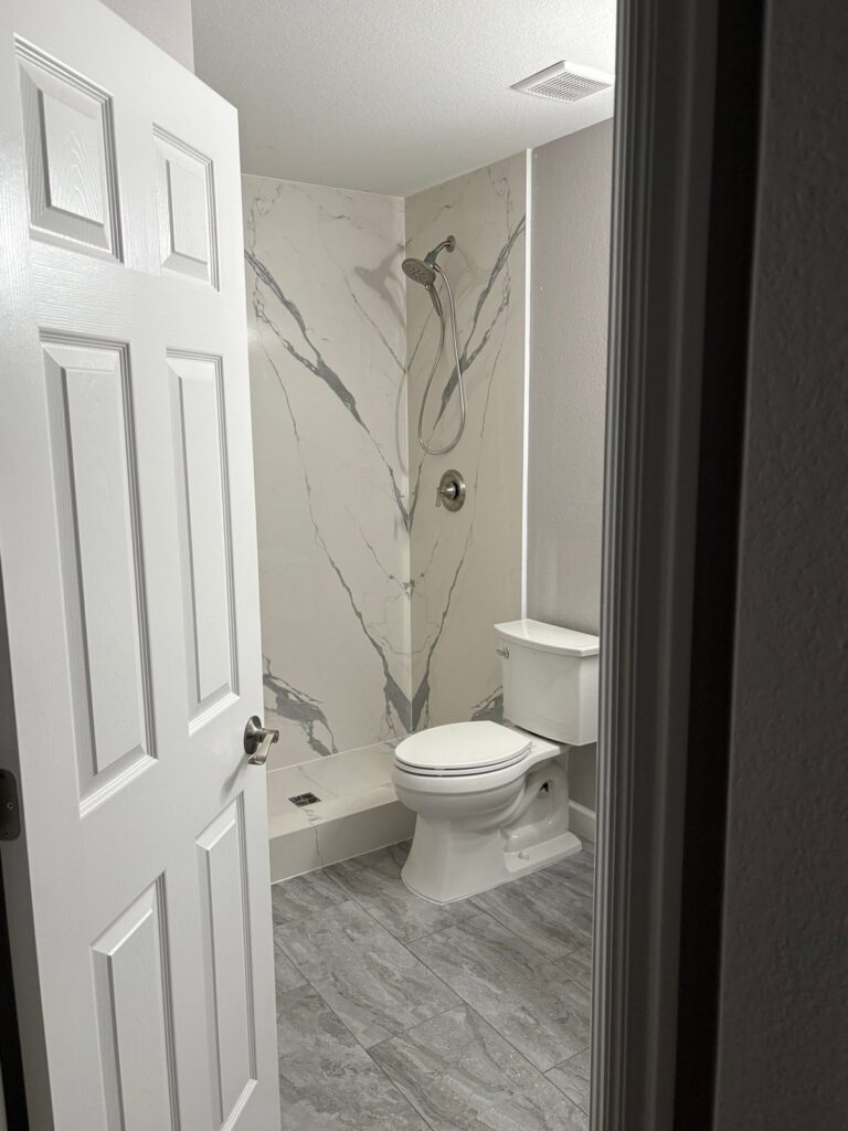 After: Highlands Ranch tub-to-shower conversion with large porcelain slab walls and gray tile floor
