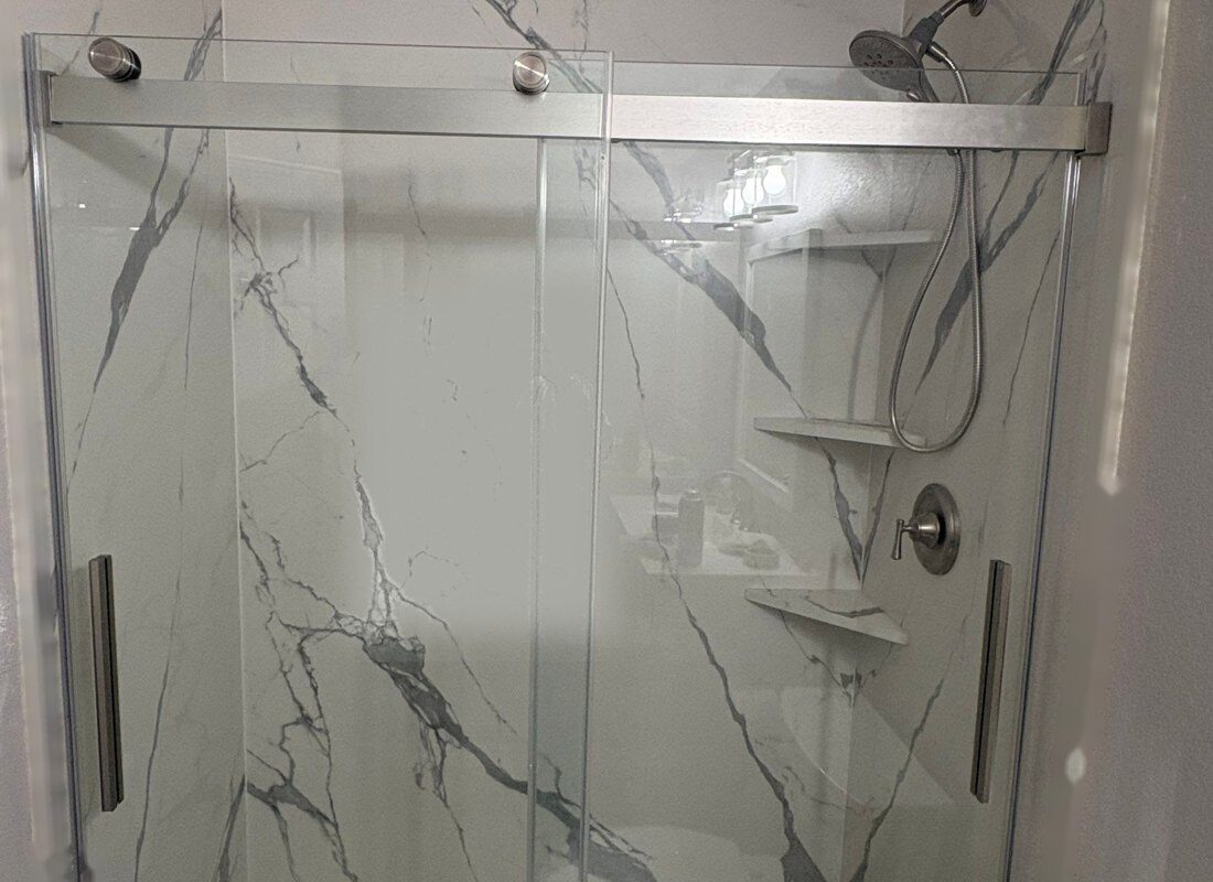 Finished tub-to-shower conversion in Highlands Ranch with marble-look porcelain slab walls and a sliding glass door