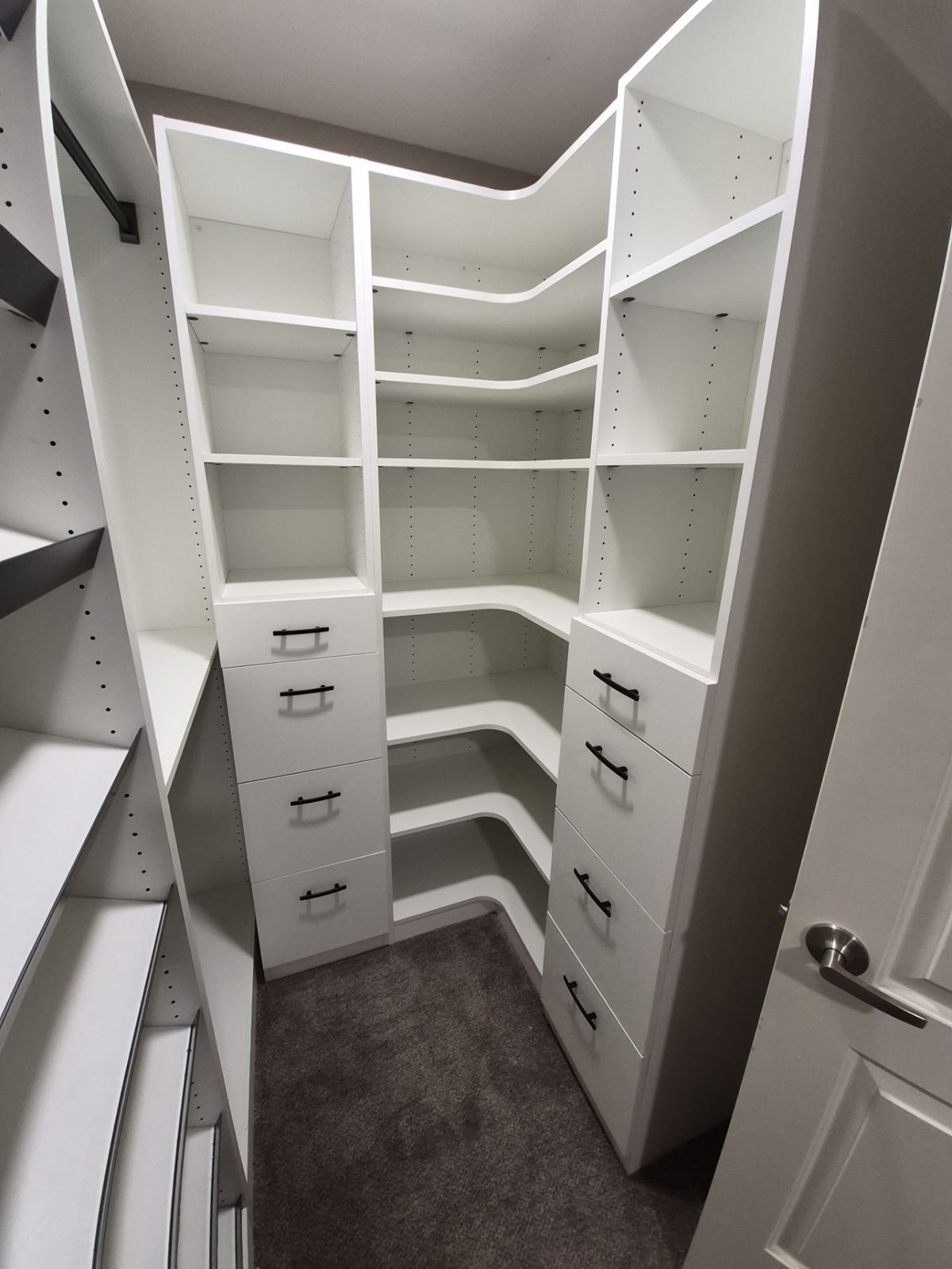 After: custom white walk-in closet system with curved corner shelves and drawer stacks, Highlands Ranch