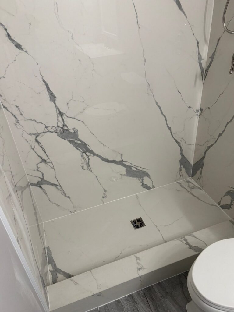 Highlands Ranch walk-in shower with porcelain slab walls, curb and square drain