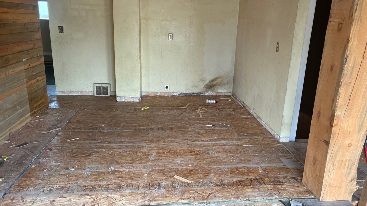 Investor rehab before: stripped subfloor and stained walls, Fort Morgan