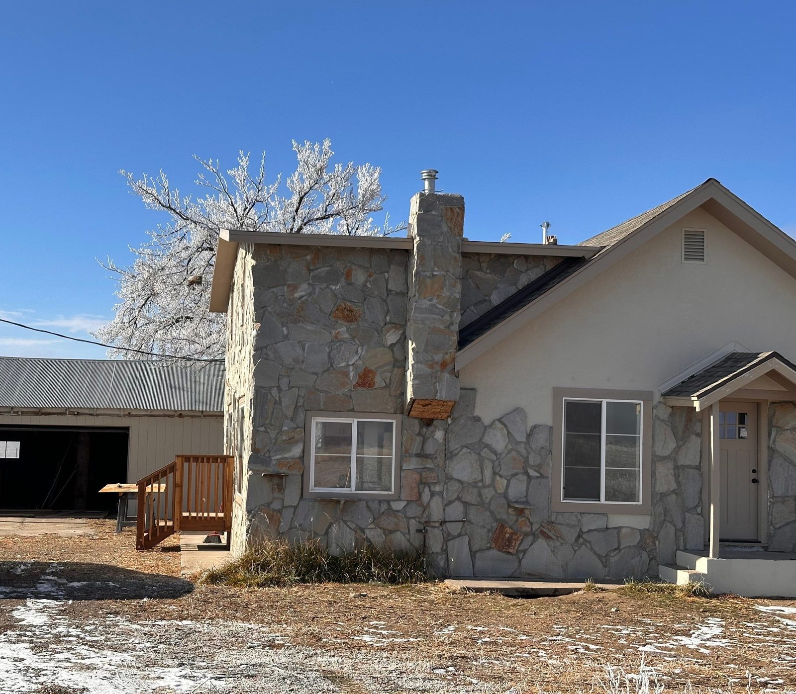 After: fresh stucco, new windows and trim, new covered porch and cedar deck stairs, Fort Morgan