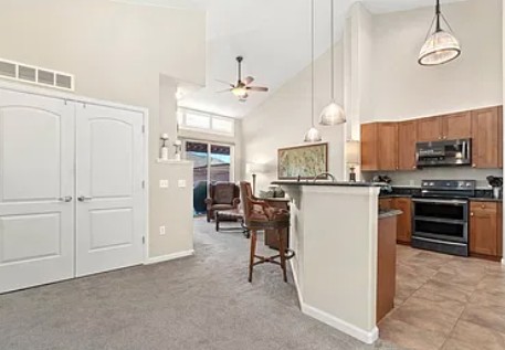 Before: Highlands Ranch townhome kitchen and great room with old carpet and tile
