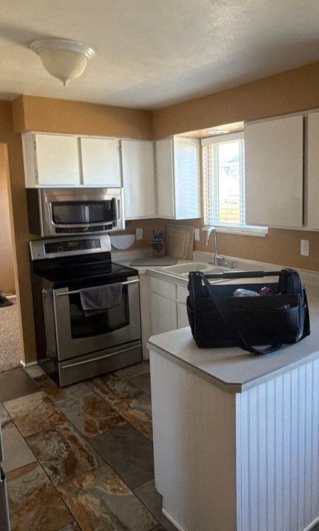 Before: Littleton kitchen with white cabinets, laminate counters and a closed-in peninsula