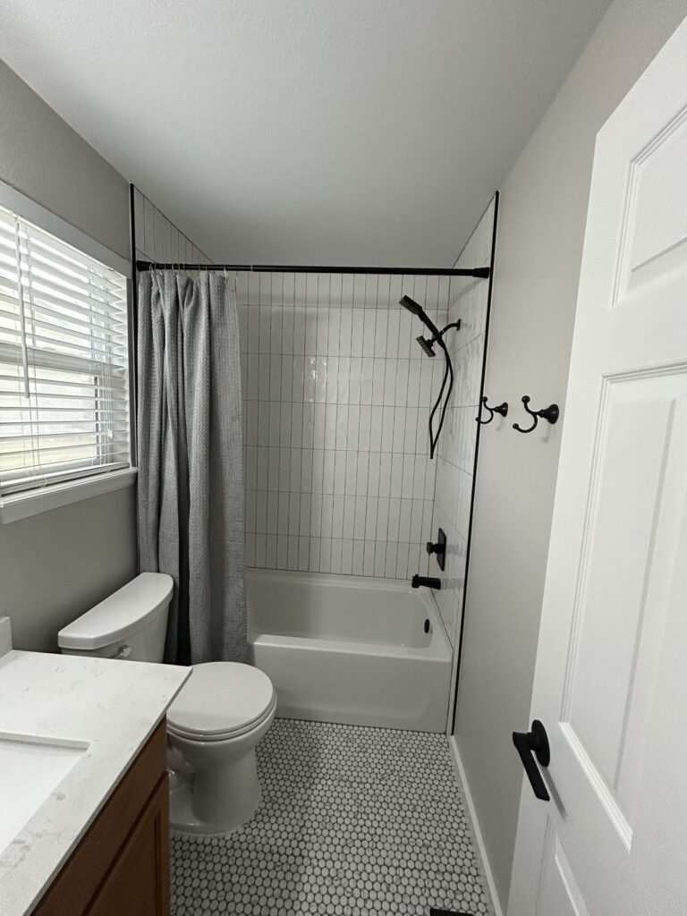 Parker hall bath remodel with white vertical tile, penny tile floor and matte black fixtures