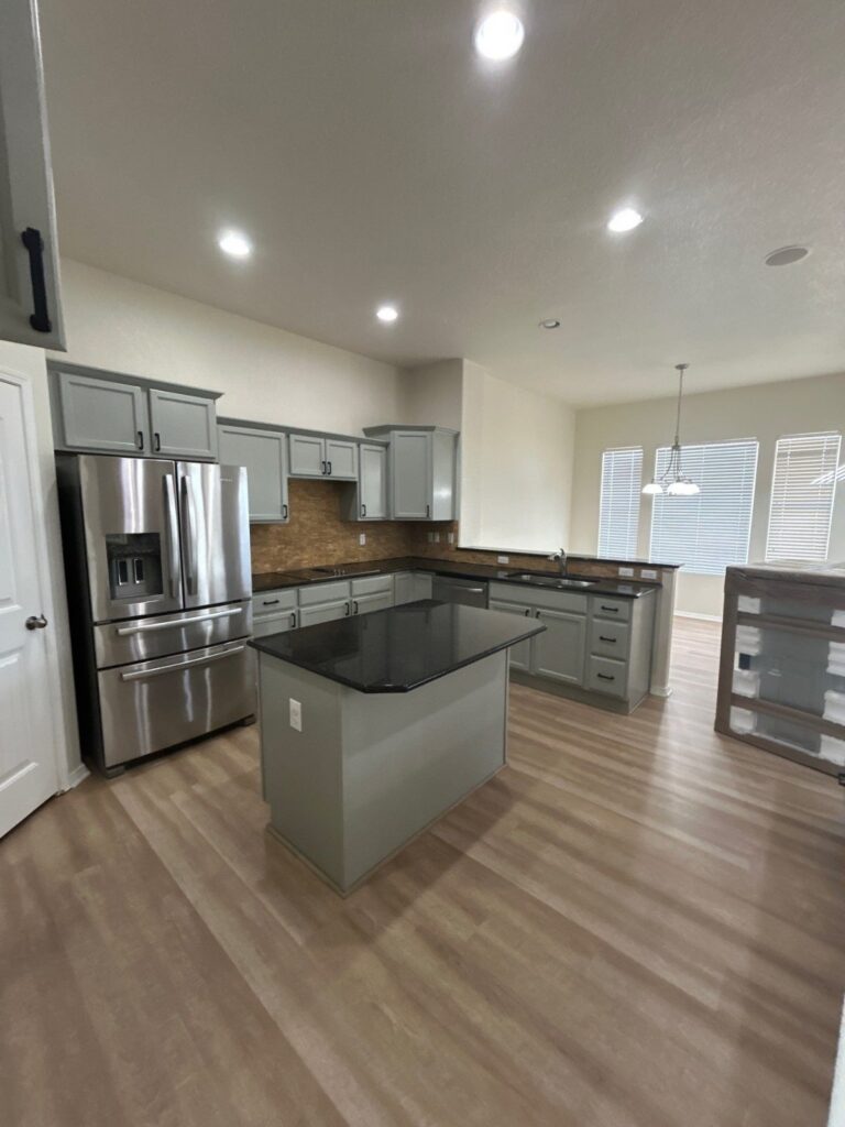 After: kitchen island and perimeter cabinets painted gray with black hardware, Peyton investor make-ready