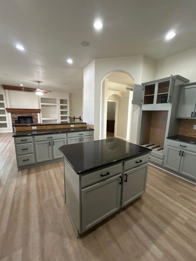 After: kitchen opening to the great room, cabinets painted and ready to list