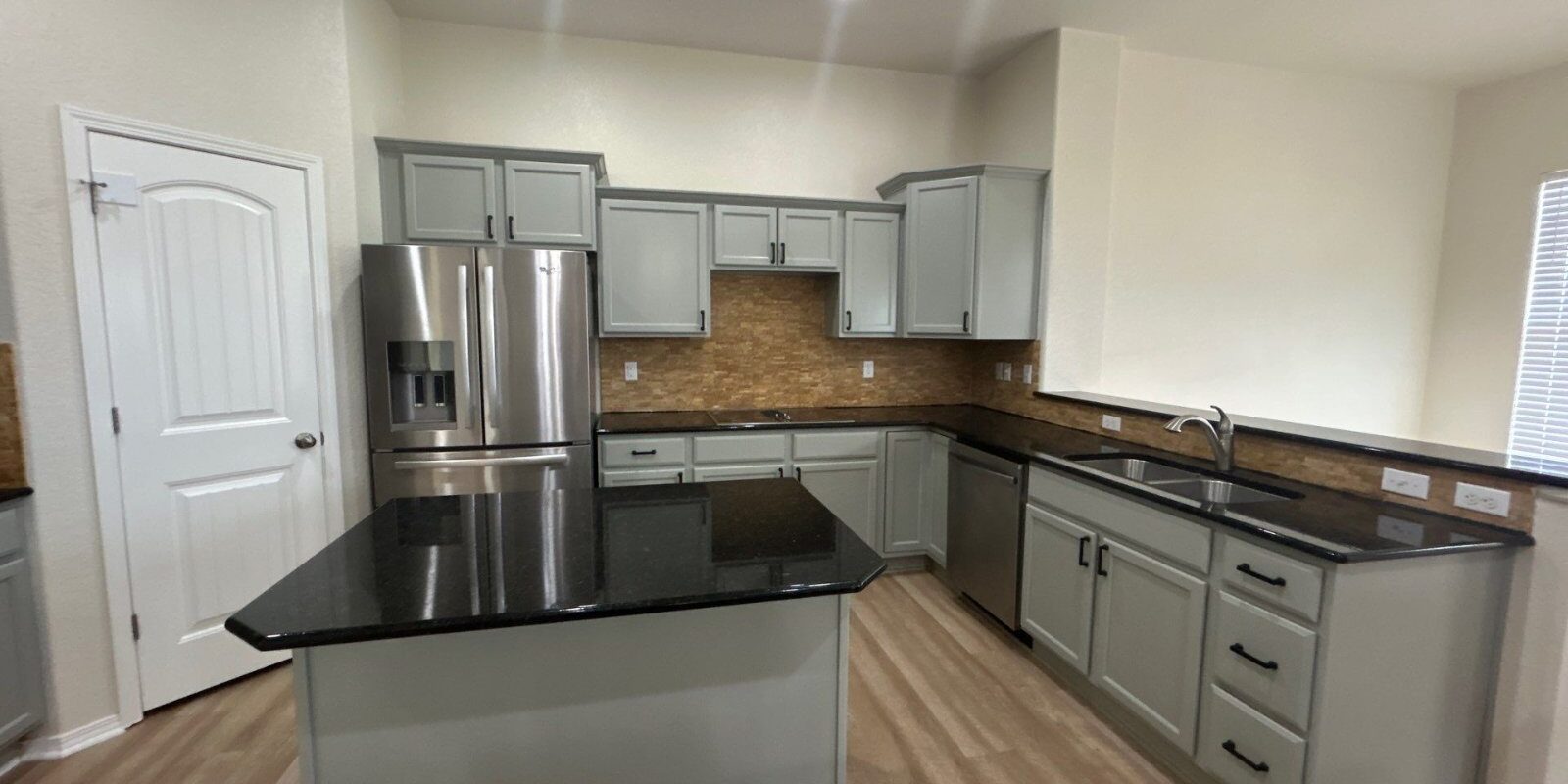 After: kitchen with cabinets painted Escape Gray, new black pulls, Peyton investor make-ready