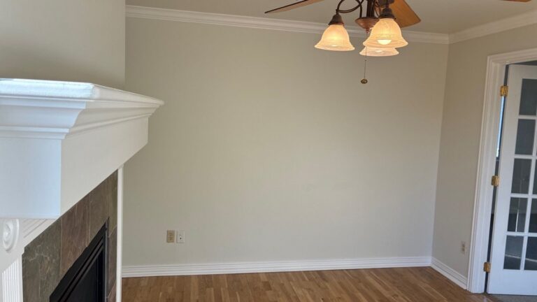 After presale repair, Parker sitting room: patched green walls repainted neutral, French door painted white