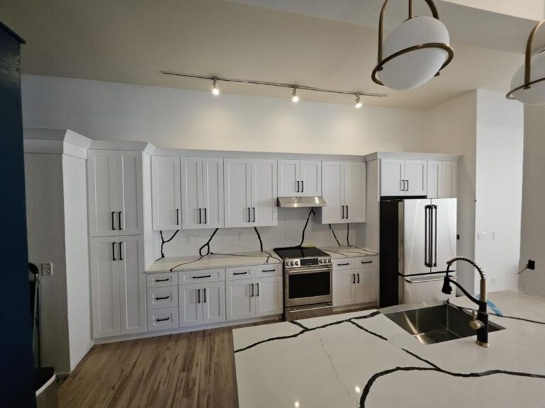 White shaker kitchen remodel with black-vein quartz island by Brimie Contractors